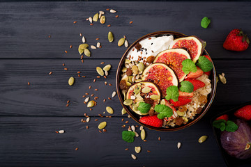 Delicious and healthy oatmeal with figs, seeds, strawberry and yogurt. Healthy breakfast. Fitness food. Proper nutrition.
