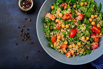 Dietary menu. Healthy vegan salad of fresh vegetables - tomatoes, chickpeas, spinach and quinoa in a bowl.