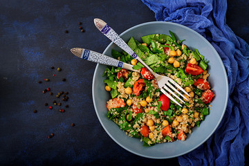 Dietary menu. Healthy vegan salad of fresh vegetables - tomatoes, chickpeas, spinach and quinoa in a bowl.