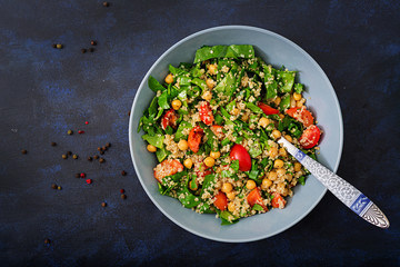 Dietary menu. Healthy vegan salad of fresh vegetables - tomatoes, chickpeas, spinach and quinoa in a bowl.