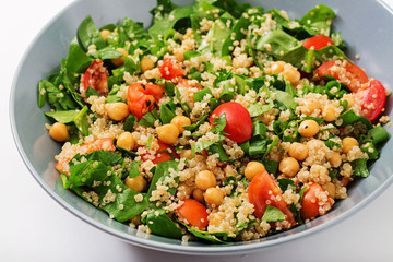 Dietary menu. Healthy vegan salad of fresh vegetables - tomatoes, chickpeas, spinach and quinoa in a bowl.