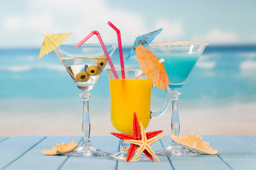 Cocktail, glass of juice and alcohol with olives, umbrellas and straws