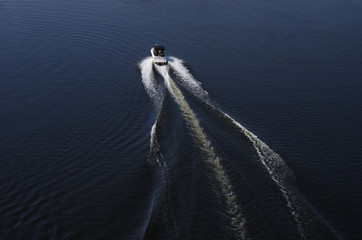 fast motor boat on a dark water surface © valeie