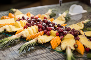 fruit on a plate, strawberry, grapes, orange, pineapple. Buffet, Catering