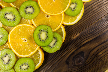 Naklejka na ściany i meble Sliced kiwi fruits and oranges on wooden table