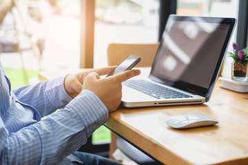 Business man at working with financial reports and using mobile smartphone in the office