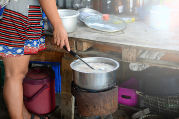 an asian woman makes  mush for breakfast  in the morning