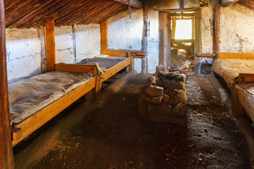Interior of a cottage with beds and a fireplace