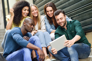 Multi-ethnic group of young people looking at a tablet computer