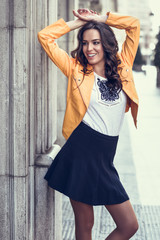 Obraz premium Young brunette woman smiling in urban background.