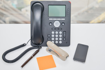 IP Phone and mobile phone and Stapler on the table