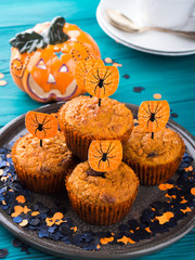 Pumpkin muffins with chocolate chips for Halloween kids party. Holiday decorations