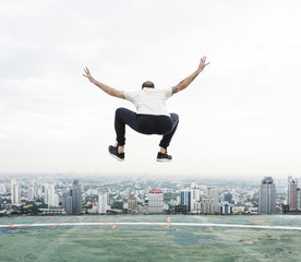 Fototapeta na wymiar Man jumping on the rooftop