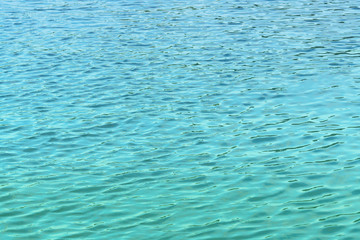 Turquoise water with small waves as background, texture