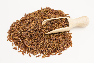 red rice grains on wooden scoop