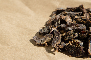 Biltong (protein snack) on brown paper, this is a traditional food snack that can be found in South Africa. This image has selective focusing.