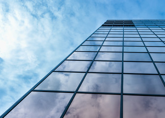 Fototapeta na wymiar Clouds reflected in windows of modern office building