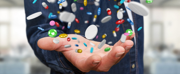 Businessman holding and touching floating medicine pills 3D rendering