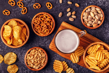 Beer with snacks on stone background.