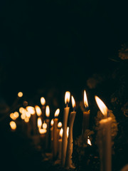 Many burning candles light in dark night