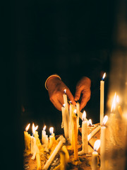 Female hand with Many burning candles light in dark night