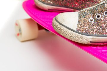 Close up of girls shoe on a pink skateboard