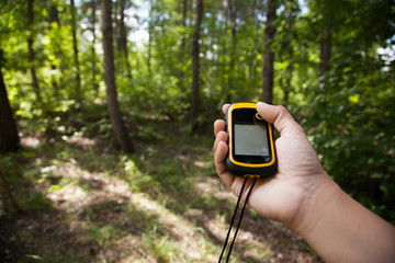 Finding position with gps device outdoor. Background blur.