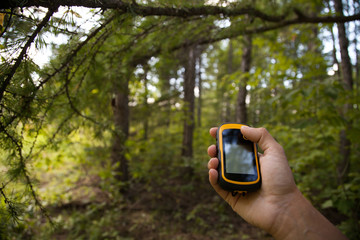 Finding position with gps device outdoor. Background blur.