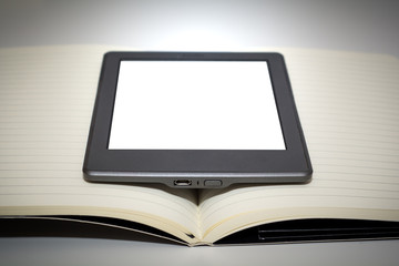 e reader device in the middle of the pages of a blank book