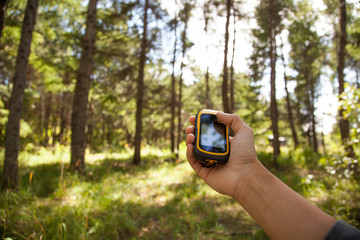 Finding position with gps device outdoor. Background blur.