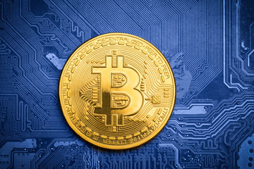 golden bitcoin on top of a blue printed circuit board