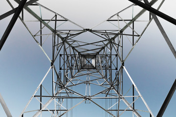 high-voltage power lines at blue sky electricity transmission pylon. Part of high-voltage substation with switches and disconnectors.