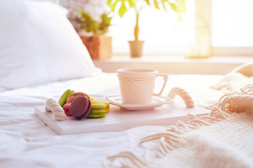 Yummy macaroons with a cup of tea on tray