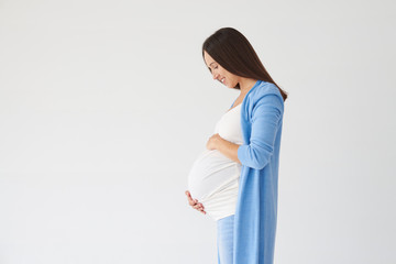 Side view of woman looking at pregnant belly