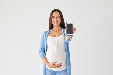 Pregnant woman showing display of mobile cell phone