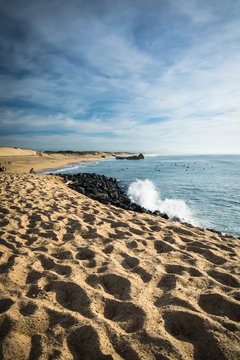 scenic sandy beach on atlantic coastline with breaking waves in blue sky, capbreton, les landes, france