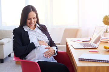 Fototapeta na wymiar Pregnant businesswoman sitting at workplace