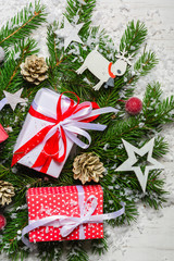 New Year and Christmas background on an white wooden background. View from above. Christmas tree branches and snow, gifts and decorations.