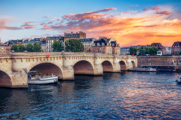 Naklejka premium Famous Pont Neuf in Paris, France. Spectacular cityscape with dramatic sunset sky. Travel background.