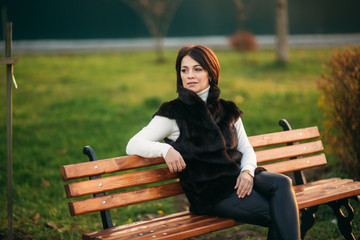 Little girl with mother walking in the park in autumn