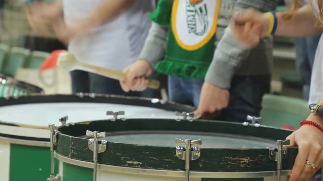 Drummer fans beat rhythm on drum at grandstand