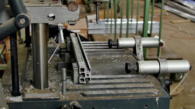 Drilling of an aluminum profile on a milling machine. Construction of winter gardens and panoramic blocks. Modern technologies in factory for manufacturing plastic windows.