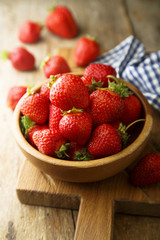 Fresh strawberry in rustic wooden bowl