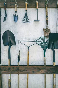 Gardening tools put to slot made from wood and hang up tidy.