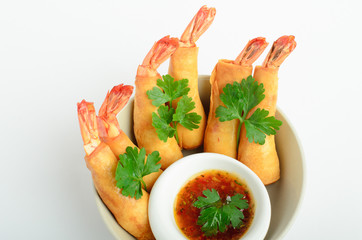Srimps in batter with sweet and sour sauce decorated parsley in a bowl isolated on white background