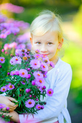 Fototapeta premium beautiful girl is walking in the evening park, hugging a big bouquet of flowers.
