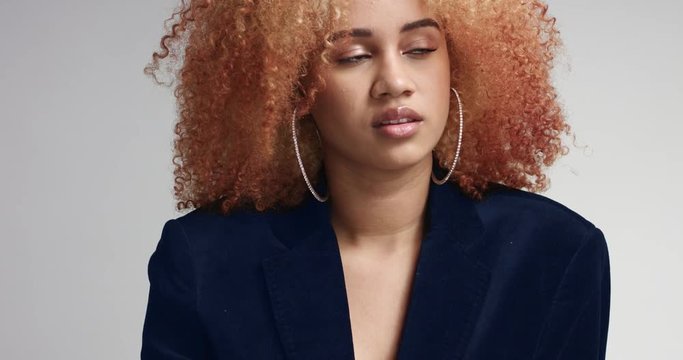 Pretty attractive young mixed race model with large afro wearing navy jacket over her naked body and shorts