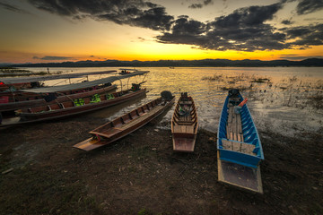 Fototapeta na wymiar Traditional wooden fishing boats beside the river at twilight time in Kanchanaburi province, Thailand.