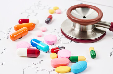 Heap of color pills and tablets with stethoscope medical.