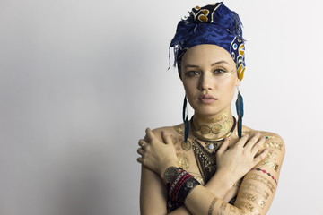 Oriental girl in African clothes Arab girl in an African style dress with a headscarf and earrings...